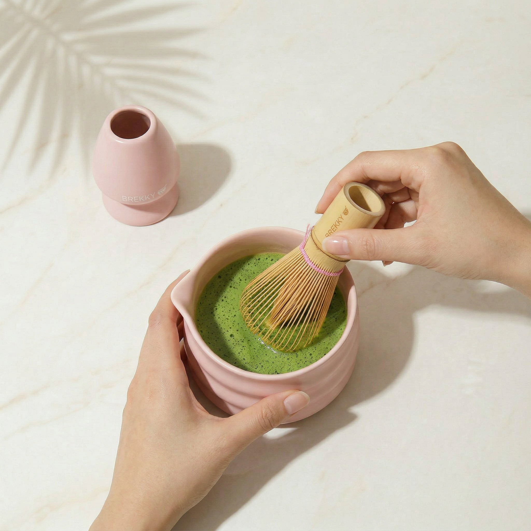 Matcha wordt in een roze kom opgeklopt