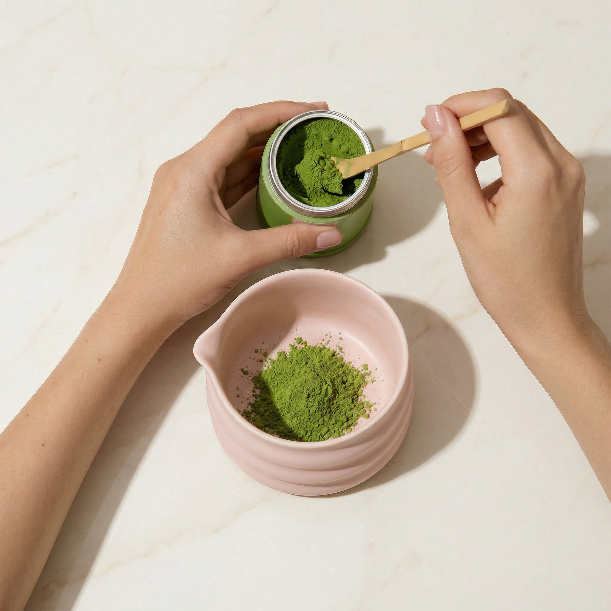 Matcha-poeder wordt met een lepel in een kommetje geschept