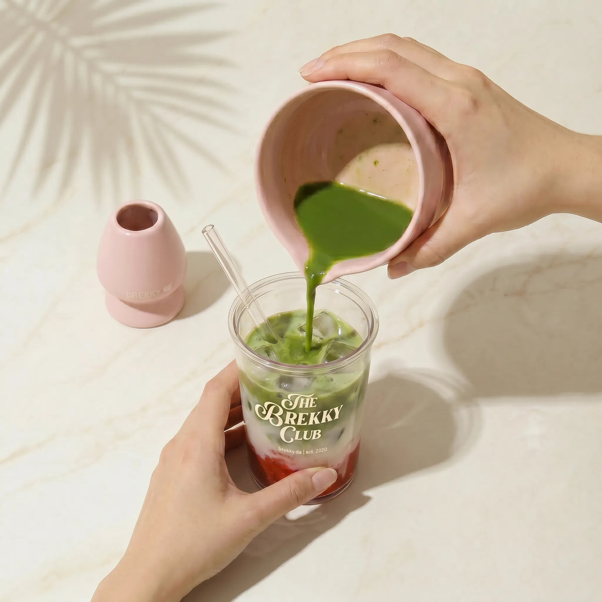 Matcha wordt in het glas met aardbeien gegoten